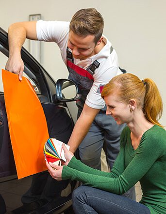 WD - Car branding specialist consults different types of adhesive foils or films for wrapping vehicles